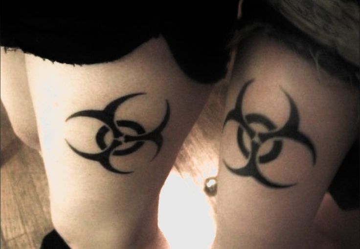 two women with tattoos on their legs and one has a biohazard tattoo on her leg