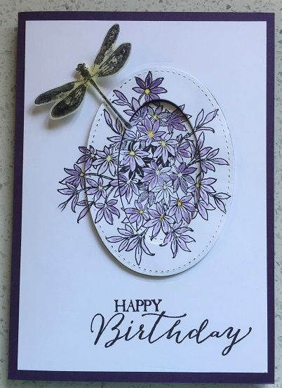 a birthday card with a dragonfly on it and flowers in the center, which reads happy birthday