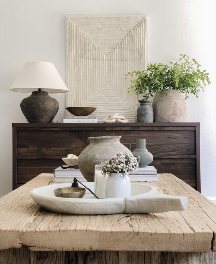 a wooden table topped with vases and books