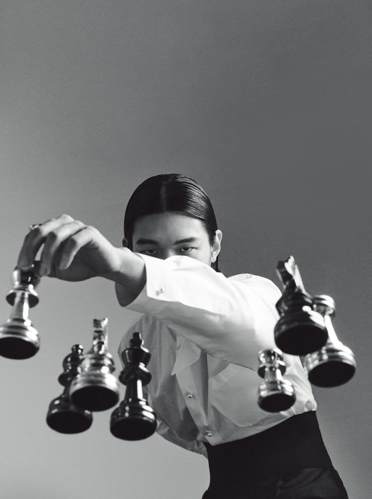 a woman is posing with several bells in her hand and she has one arm extended