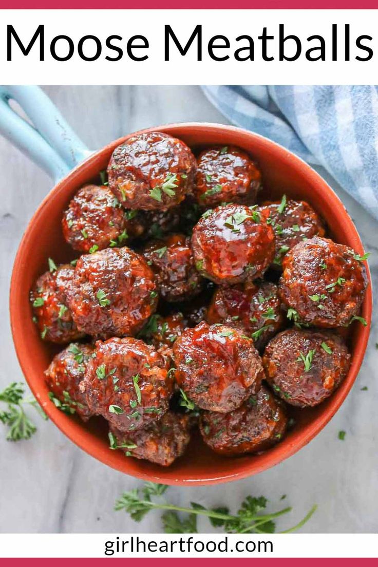 a bowl filled with meatballs and garnished with parsley in the middle