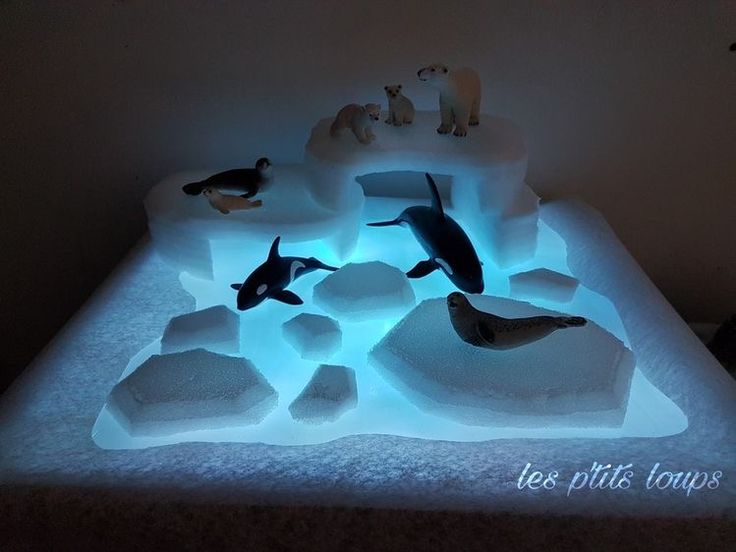 an ice sculpture with various sea animals on it's sides and lights in the middle