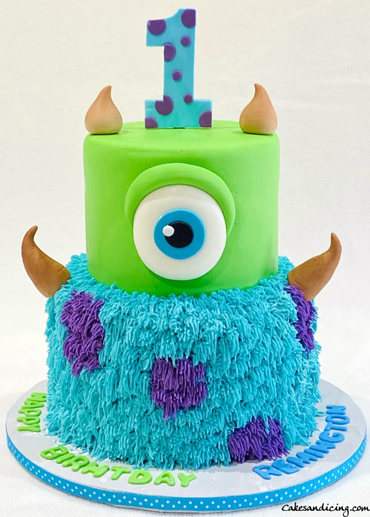 a blue and green birthday cake with an eye on it's top that says 1