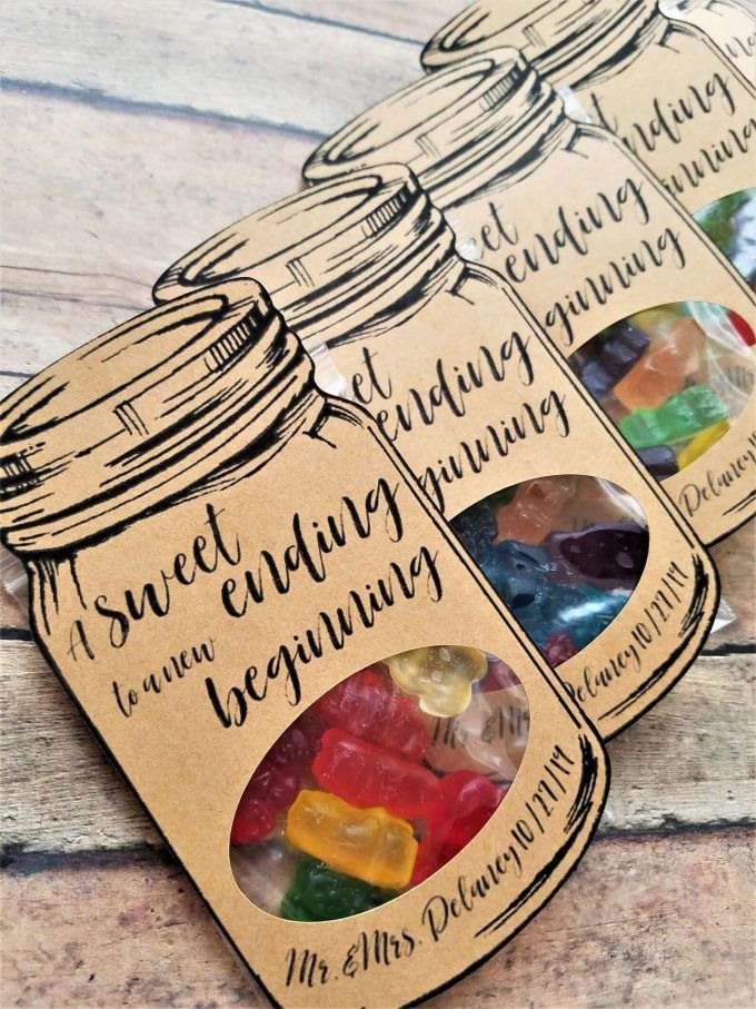 three jars filled with gummy bears sitting on top of a wooden table