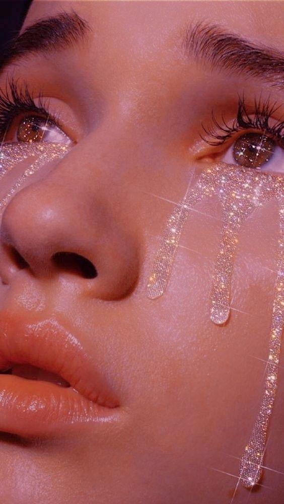 a close up of a woman's face with water dripping from her eyes and eyelashes