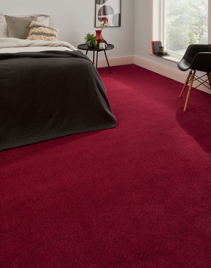 a bedroom with red carpet and white walls