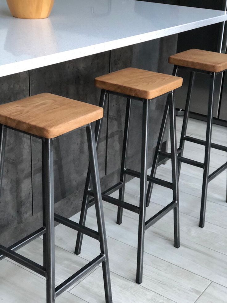 three wooden stools sitting on top of a counter next to a potted plant