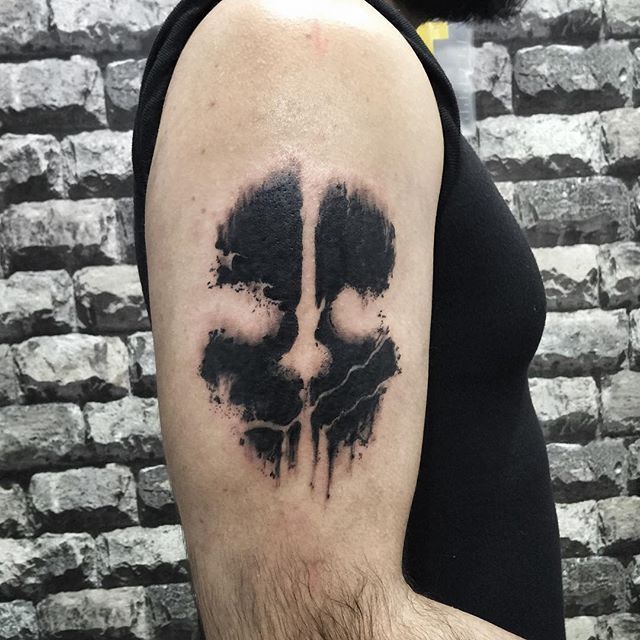 a man's arm with a black and white inked skull tattoo on it