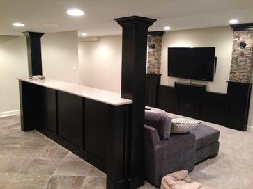 a living room with an entertainment center, couches and a flat screen tv on the wall