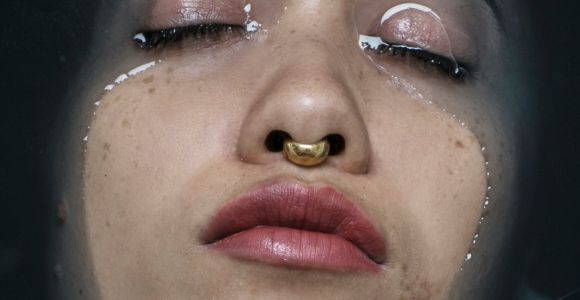 a close up of a woman's nose and nose ring with glitter on it