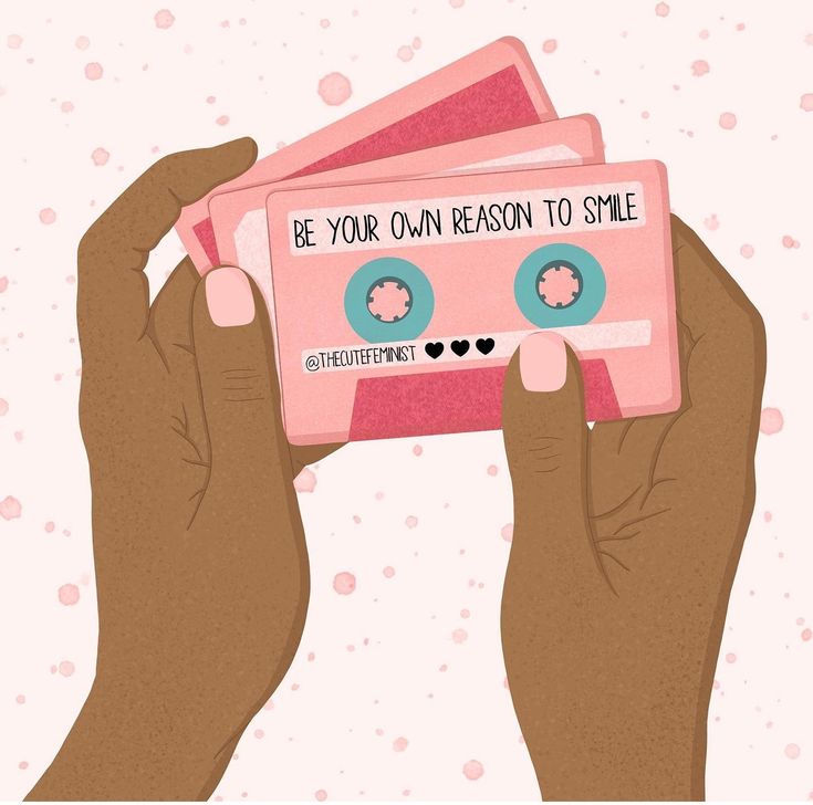 two hands holding pink cassettes with the words be your own reason to smile