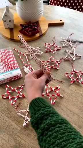 someone is decorating their christmas tree with red and white candy canes on the table