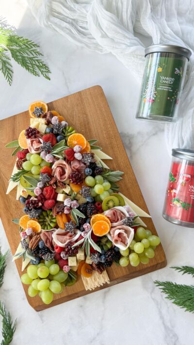 a wooden cutting board topped with fruit and veggies