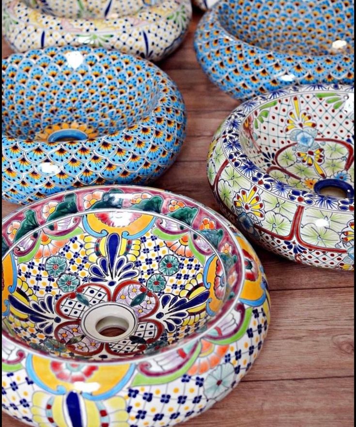 many colorful bowls are sitting on the floor