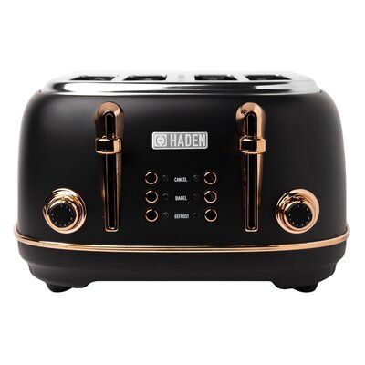 a black toaster with gold trim and knobs on the front is sitting in front of a white background