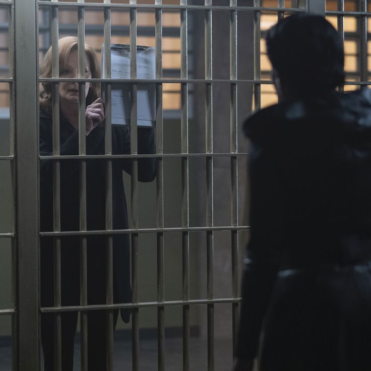 a woman holding a piece of paper behind bars