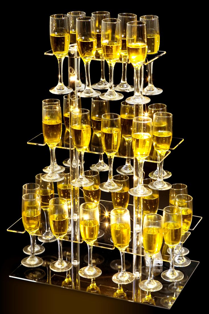 a display case filled with lots of wine glasses on top of each other and yellow liquid in the middle