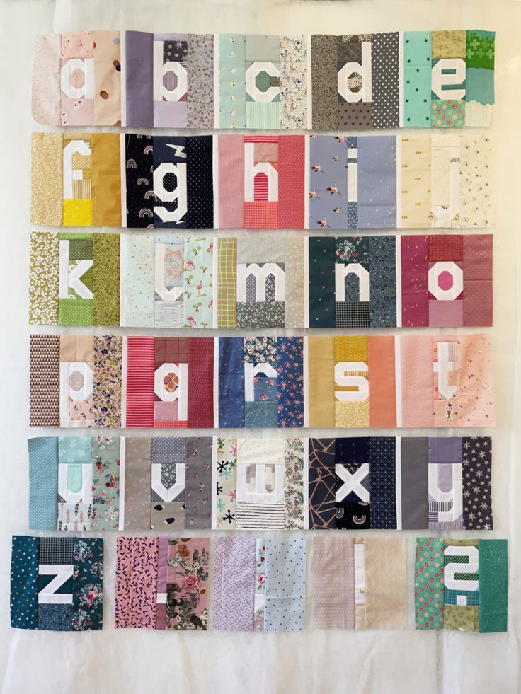 a quilted wall hanging with alphabets and numbers on it's sides in different colors