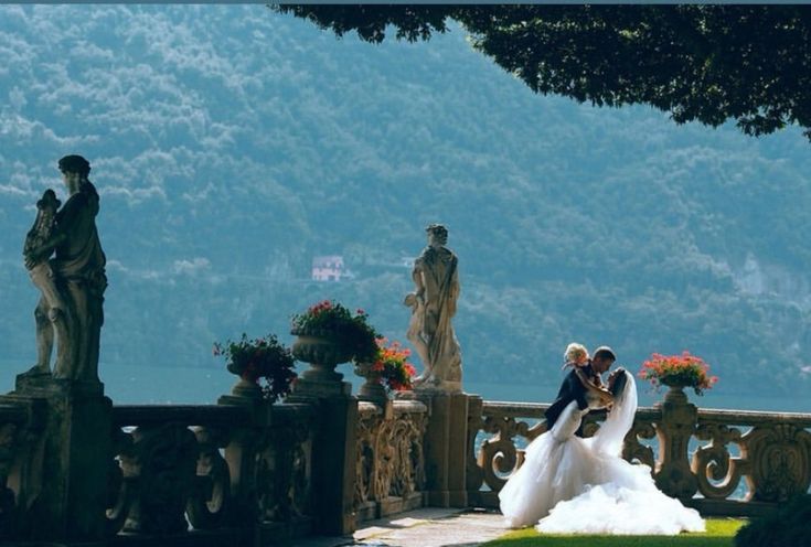 the bride and groom are posing for pictures on their wedding day in front of some statues