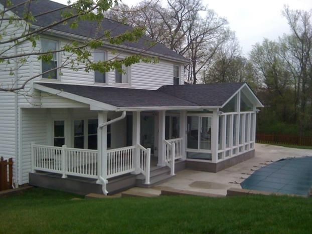 a large white house with a pool in the front yard and covered patio area next to it