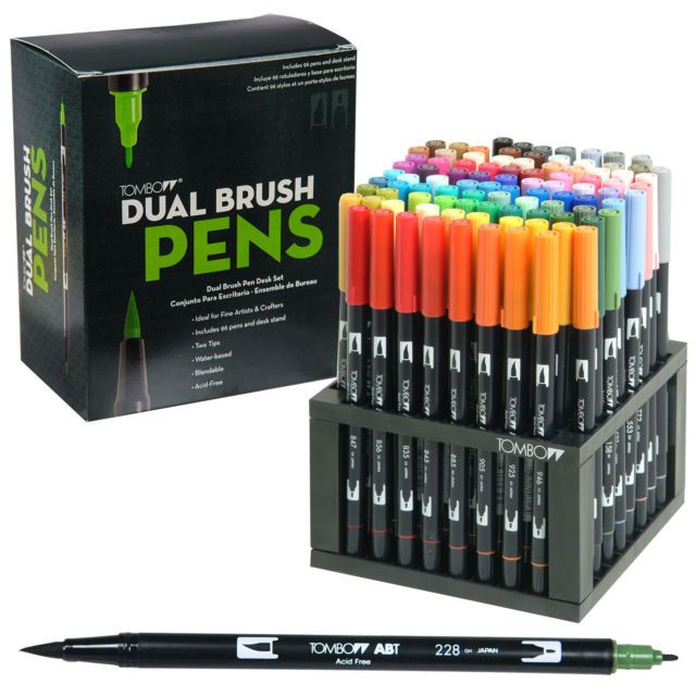 the dual brush pens are in a display case and it is next to an empty box