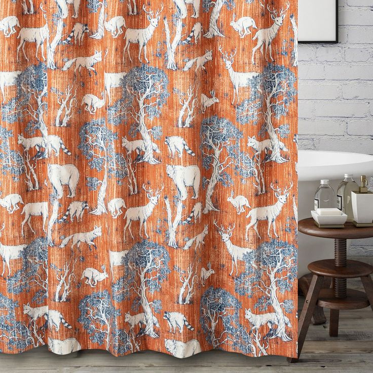 an orange shower curtain with white deer and trees on it