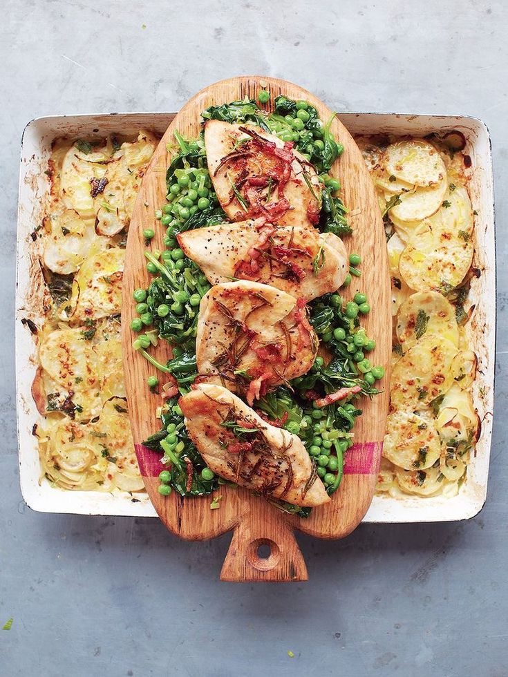 a wooden platter filled with meat and vegetables