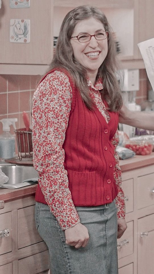 a woman standing in a kitchen next to a sink