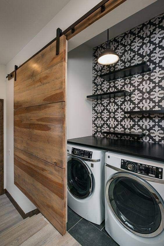 a washer and dryer sitting next to each other in front of a wooden door