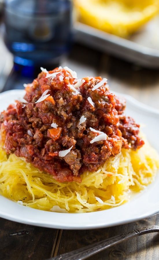 spaghetti with meat sauce and cheese on a white plate