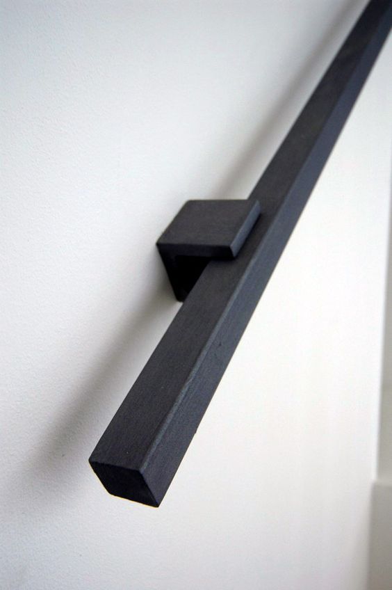 a black metal handle on a white wall