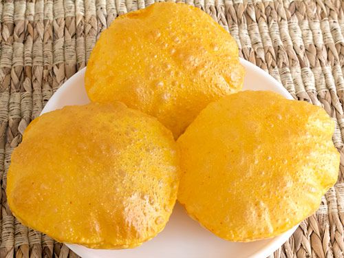 three yellow cakes sitting on top of a white plate