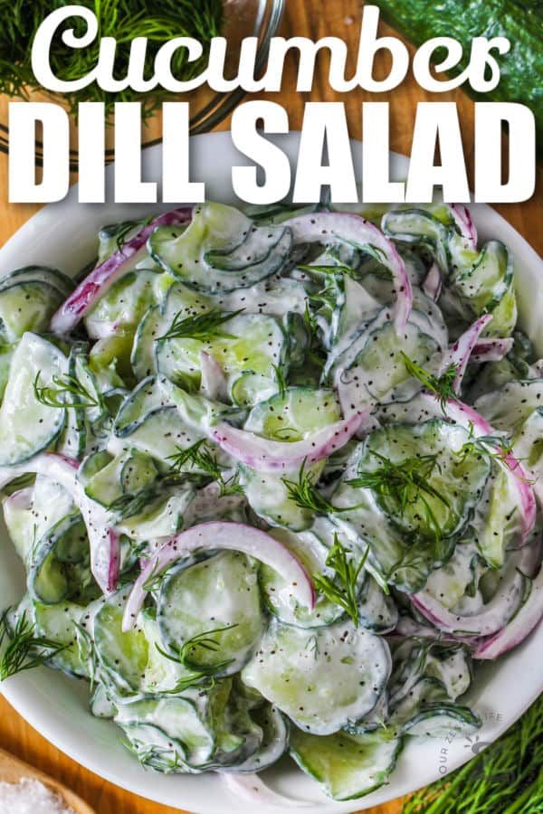 cucumbers and dill salad in a white bowl