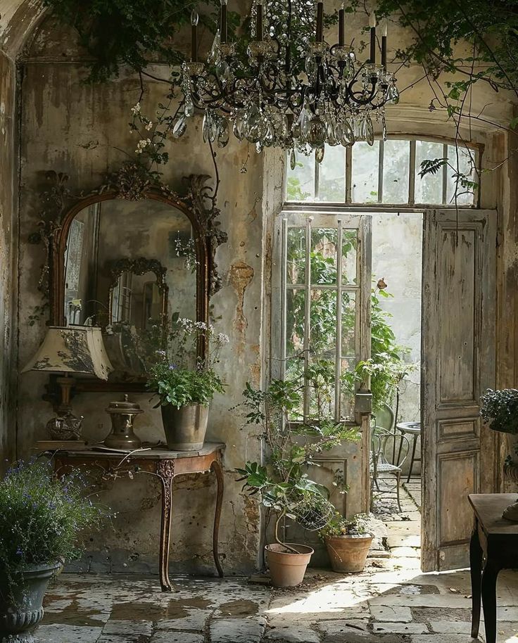 an old house with potted plants and a chandelier hanging from the ceiling