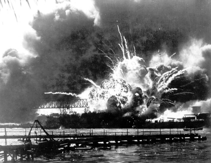 an old black and white photo of fireworks in the sky over water with boats on it