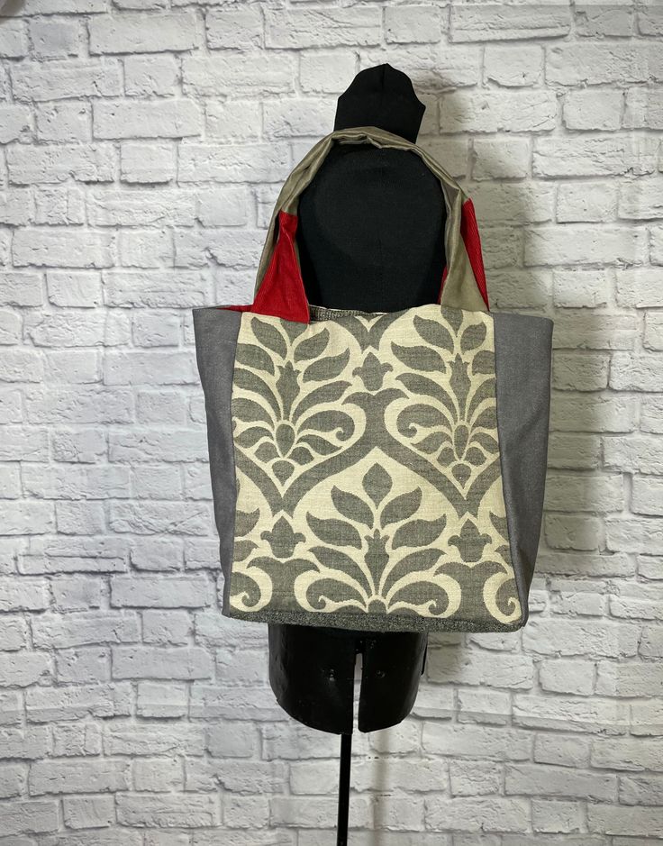 a tote bag sitting on top of a mannequin's head in front of a brick wall