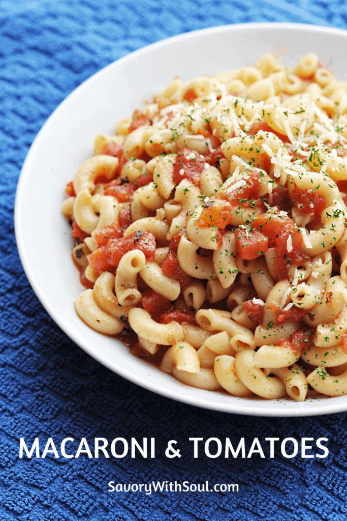 macaroni and tomatoes with parsley in a white bowl on a blue towel