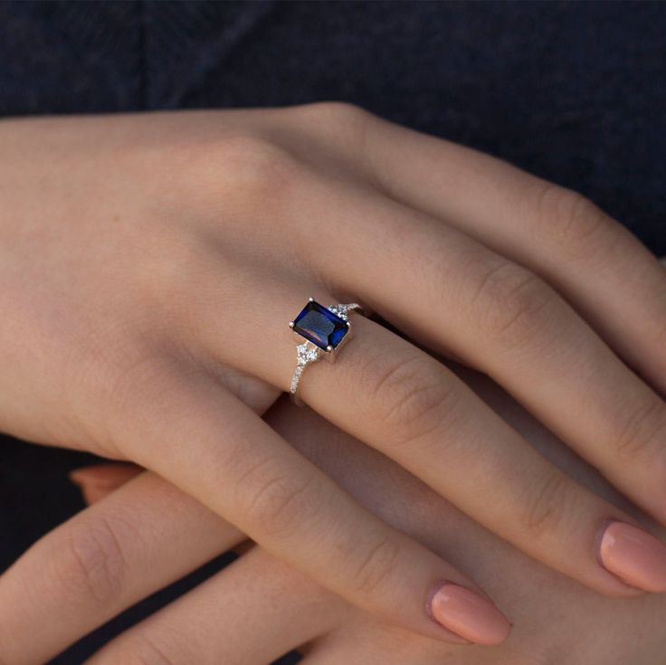 a woman's hand with a diamond and sapphire ring