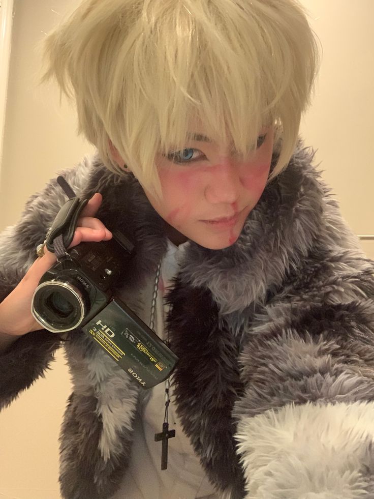 a woman taking a selfie in front of a mirror with a camera and wearing a fur coat