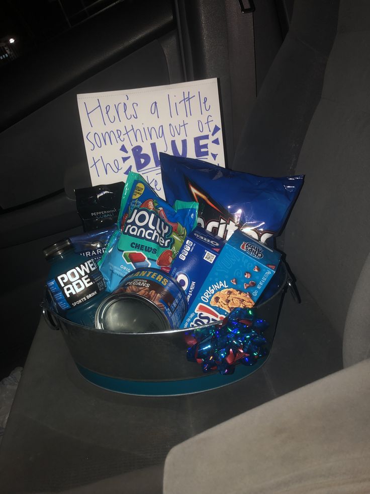 a car seat filled with snacks and condiments next to a sign that says here is a little something in the drive