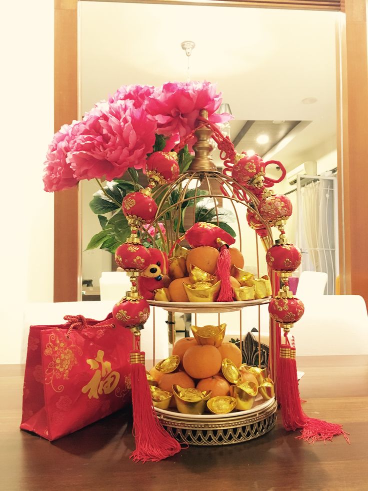 a birdcage filled with fruit and flowers on top of a table