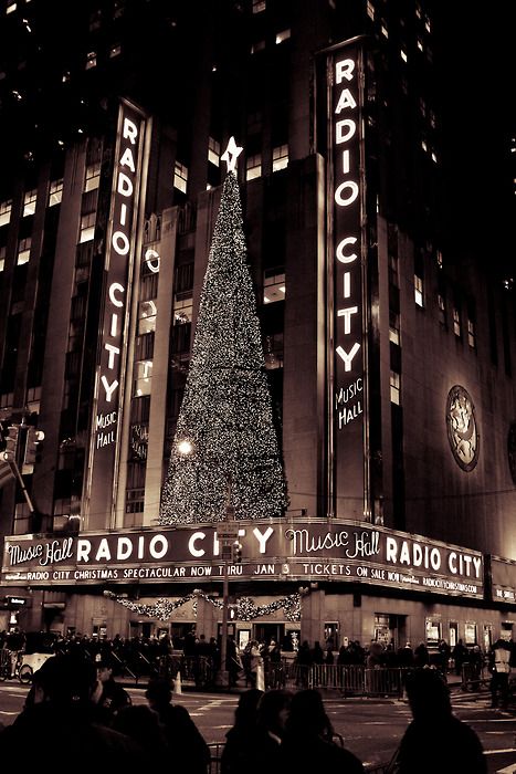 the radio city christmas tree is lit up at night