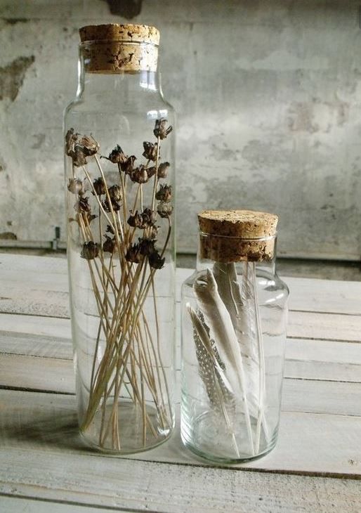 two glass bottles with dried flowers in them