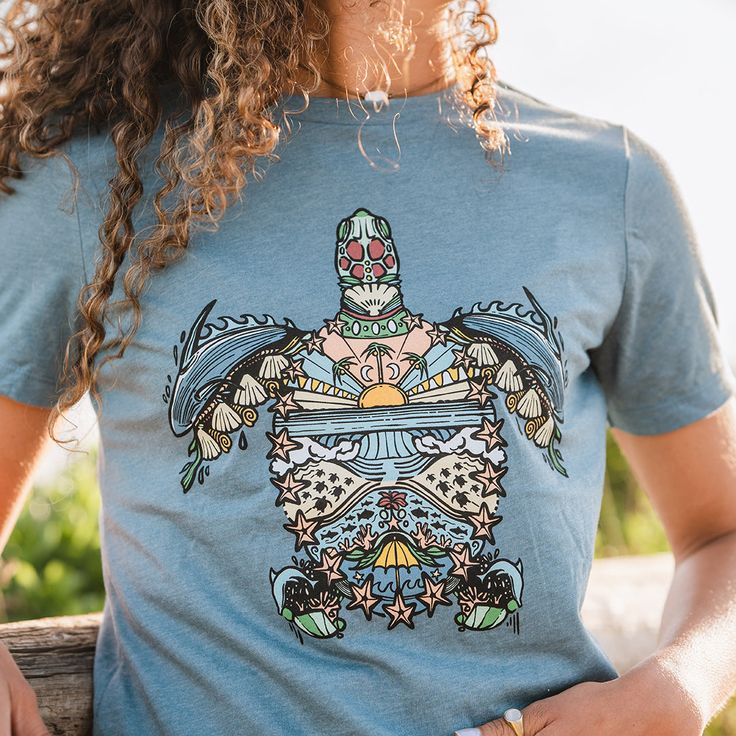 "Boho" is short for Bohemian, which embodies the free spirit of this eclectic, tribal inspired sea turtle design. The elements within are inspired by our natural world and the simplicity, yet made to be intricate and complex. Tap into your bohemian side with this Boho Sea Turtle women's T-Shirt. Support the parks with this women's Boho Sea Turtle shirt. Free shipping on orders more than $100. RELAXED FIT. Bohemian Short Sleeve Beach T-shirt, Blue Bohemian T-shirt For Summer, Bohemian Blue T-shirt For Summer, Bohemian T-shirt For Beach With Short Sleeves, Bohemian Short Sleeve T-shirt For Beach, Bohemian Beach Tops With Graphic Print, Bohemian Graphic Print Beach Tops, Bohemian Graphic Print T-shirt For Vacation, Bohemian Blue T-shirt With Graphic Print