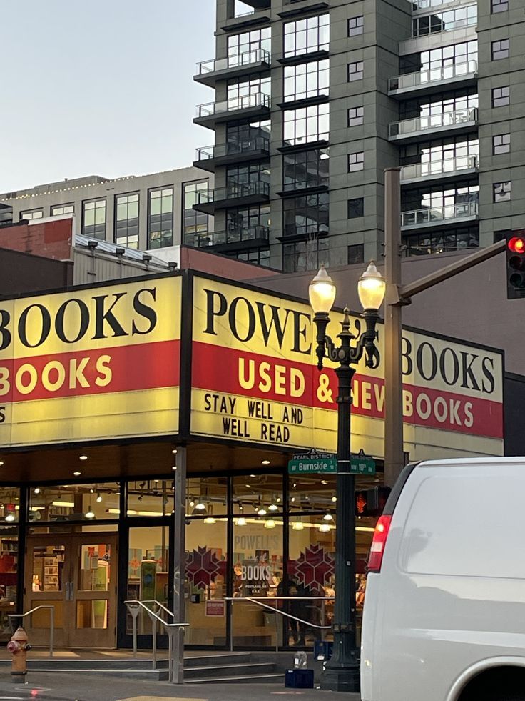 a book store on the corner of an intersection with traffic lights and buildings in the background