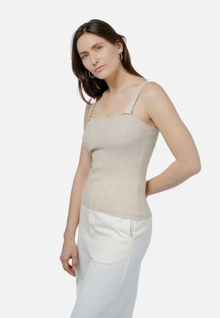 Experience snug refinement with the Ulaanbaatar Strap Top. This knitted strap top boasts a ribbed finish and a fitted silhouette, designed to accentuate your figure. With its heart-shaped neckline and wide, comfortable straps, it exudes sophistication. Crafted from plush cashmere, its soft touch against the skin is unmatched. For the ultimate ensemble, pair it with the matching Ulaanbaatar Cardigan. Details:- Knitted strap top with all over ribbed finish- Fitted silhouette - Accented transfer st Chic Fitted Ribbed Tank Top, Chic Cashmere Top With Ribbed Neckline, Chic Beige Ribbed Tank Top, Elegant Fitted Tank Knit Top, Fitted Knit Camisole For Spring, Everyday Ribbed Spaghetti Strap Tops, Fitted Elegant Tank Knit Top, Fitted Knit Tank Top, Fitted Knit Top With Tank Straps