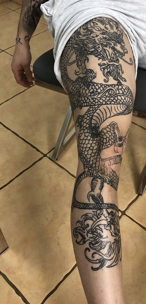 a man with a dragon tattoo on his leg