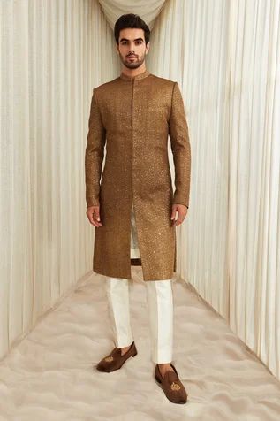 Coffee sherwani with all-over gold sequin and tonal thread embroidery. Comes with ivory straight pants.
Component: 2
Pattern: Embroidery
Type Of Work: Thread and Sequin
Neckline: Mandarin Collar
Sleeve Type: Full
Fabric: Georgette
Color: Brown,Gold
Other Details: 
Welt pocket in front
Sherwani with side slits
Note: Inner kurta worn by the model is not for sale
Occasion: Wedding - Aza Fashions Sawan Gandhi, Sherwani For Men Wedding, Wedding Kurta, Embroidered Sherwani, Sherwani For Men, Kurta Men, Wedding Dress Men, Fashion Suits For Men, Fashion Suits