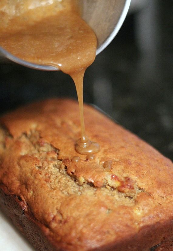 someone pouring sauce onto a loaf of bread