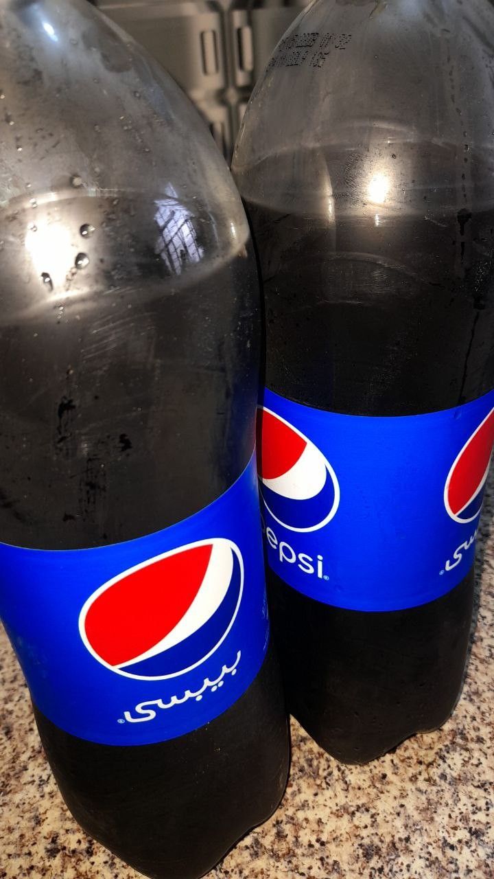 two pepsi soda bottles sitting on top of a counter